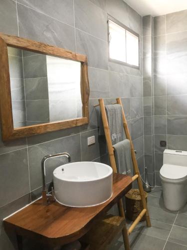 a bathroom with a sink and a mirror and a toilet at Mayara pool villas - Adults only in Haad Yao