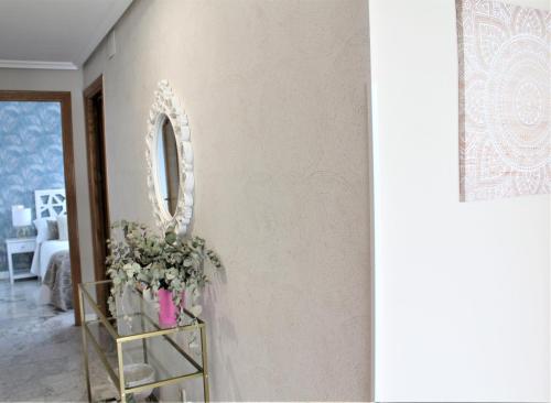 a room with a mirror and a shelf with flowers at Apartamento Vistas molineras in Consuegra
