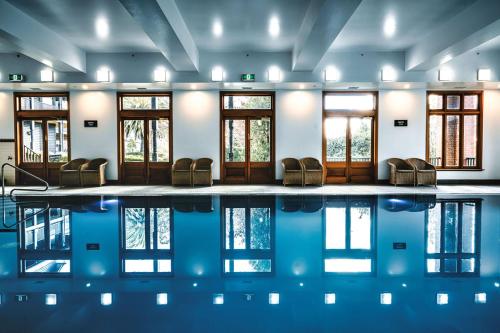 a pool in a room with chairs and windows at Hotel Bellinzona Daylesford in Hepburn Springs