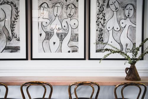a table with two chairs and a vase with a plant at Hotel Bellinzona Daylesford in Hepburn Springs