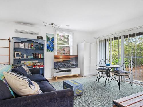 a living room with a couch and a table at Bay Cottage in Callala Bay