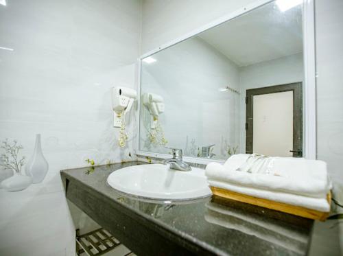 Baño blanco con lavabo y espejo en Quỳnh Trang, en Thường Son