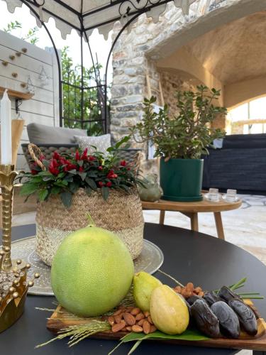 a table with a melon and other fruits and vegetables at לאורה in Umm el Shuf