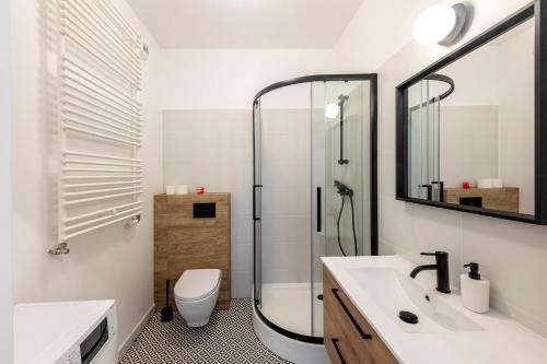 a bathroom with a shower and a toilet and a sink at Pokoje Sonaty in Warsaw