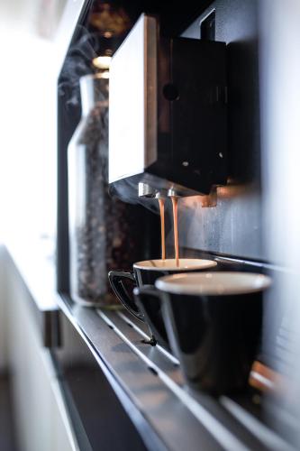 a coffee being being brewed in a microwave at sky FLAT jacuzzi sauna 27 FLOOR in Klaipėda