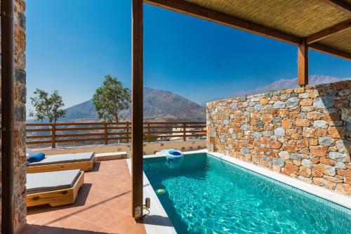 a villa with a swimming pool with mountains in the background at Galini Luxury Homes in Saktoúria