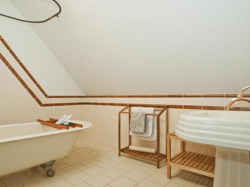 Un baño blanco con bañera y lavabo. en Izba, en Callala Bay