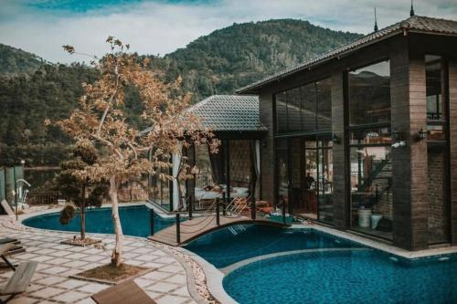 a house with a swimming pool next to a building at An Viên House Sóc Sơn Venuestay in Hanoi