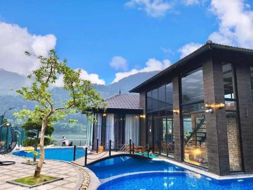 a villa with a swimming pool and a house at An Viên House Sóc Sơn Venuestay in Hanoi
