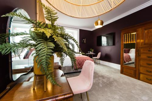 a bedroom with a bed and a plant on a table at Skeldale House 'All Creatures Great & Small' Luxury Apartments & Studios in Askrigg, Yorkshire Dales in Askrigg