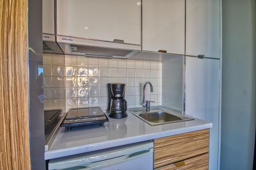 a kitchen with a sink and a coffee maker at Island Boutique Hotel in Rhodes Town