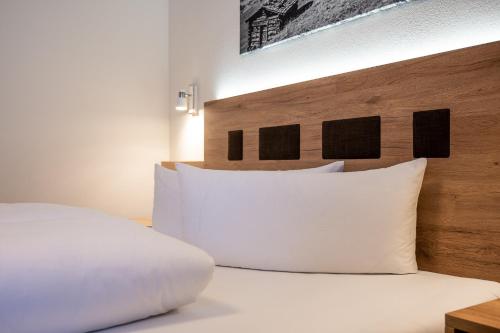 a bed with a white pillow and a wooden headboard at Tobhartbauer in Dorfgastein