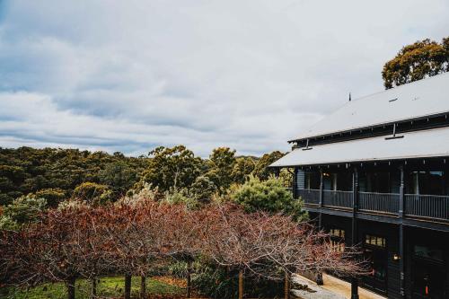 a black building with a white roof next to trees at Hotel Bellinzona Daylesford in Hepburn Springs