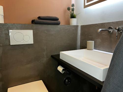 a bathroom with a white sink and a mirror at elegant and relaxing nordstadt studio in Hannover