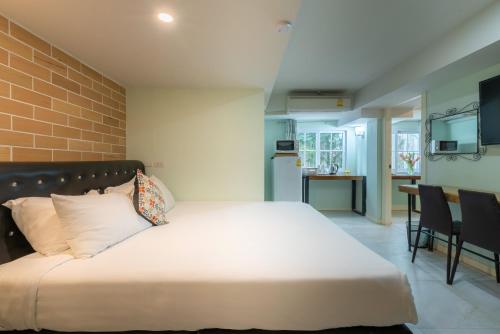 a bedroom with a large bed and a dining room at Little Bear's Home in Chiang Mai