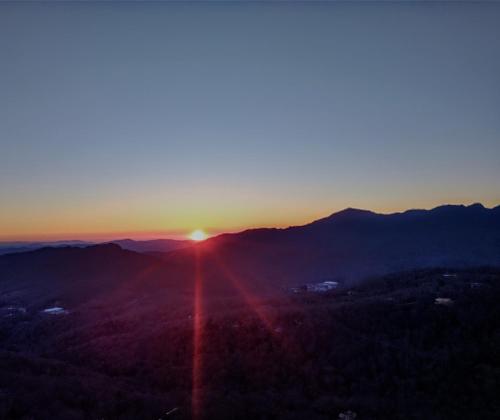 a sunset in the mountains with the sun setting at Handsome 2BR Condo with Gorgeous Views in Sugar Mountain! condo in Sugar Mountain