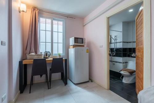 a small kitchen with a table and a refrigerator at Little Bear's Home in Chiang Mai