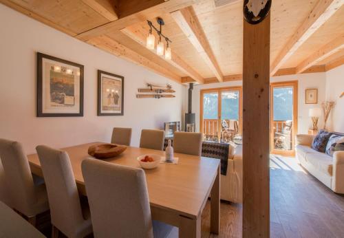a dining room and living room with a wooden table and chairs at Racers Retreat #5 in Wengen