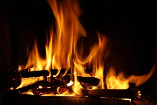 a fire with several cooking utensils in a fireplace at Villa 6 Vrchlabí in Vrchlabí