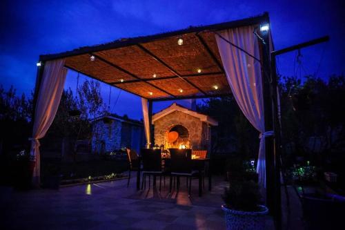 スリマにあるHoliday House Gloria Srimaの夜間のパーゴラ(テーブルと椅子付)