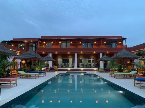 un resort con piscina di fronte a un edificio di Maison de clara a Ngaparou
