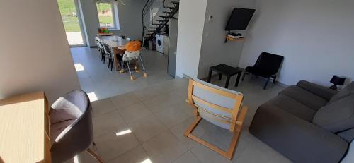 a living room with a couch and a table and chairs at La Maison de Léobin in Véranne