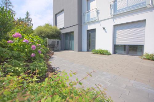 a patio outside of a house with pink flowers at Ferienwohnung Hegaublüte in Engen