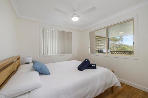a bedroom with a white bed and a window at Bellhaven 2, 17 Willow Street in Crescent Head