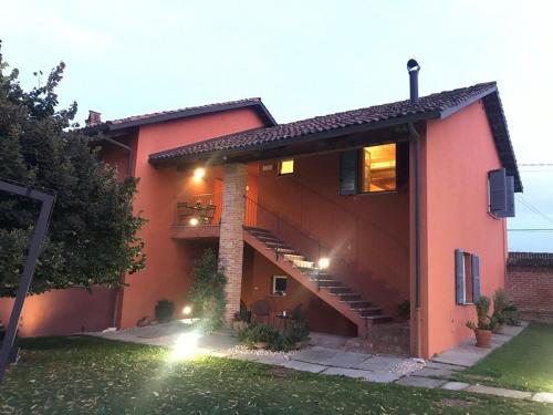 a large red house with stairs in a yard at Agriturismo Cascina Palazzo in Roddi