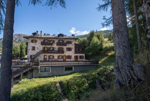a large building on a hill with trees at Baita Belvedere - Appartamenti Abar in Livigno