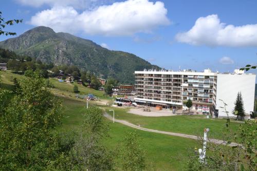 un grande edificio di fronte a una montagna di Appartement au pied des Pistes de Ski - Pyrénées (Ariège) a Montferrier