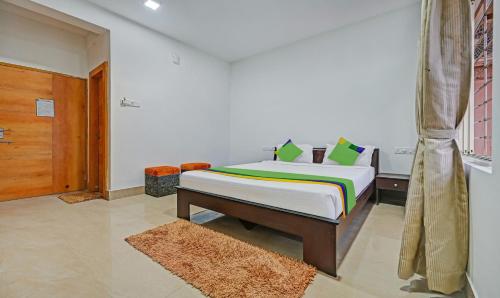 a bedroom with a bed and a window and a door at Treebo Sidhartha Inn Baliapanda in Puri