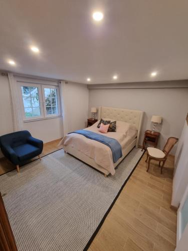 ein Schlafzimmer mit einem Bett und einem blauen Stuhl in der Unterkunft Villa Flora Superior Apartment in Cabris