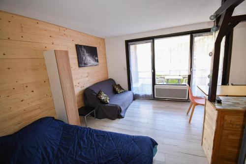 a room with a bed and a couch in it at Relai S11 Grand et lumineux studio avec coin montagne 4-6 pers, WIFI, 30m des pistes, grand balcon, DRAPS NON COMPRIS in Saint-Jean-d'Aulps