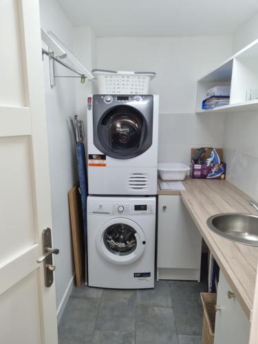 a laundry room with a washer and a washing machine at Villa Flora Superior Apartment in Cabris