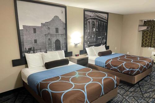 Habitación de hotel con 2 camas y una foto en la pared en Super 8 by Wyndham San Antonio Downtown NE, en San Antonio