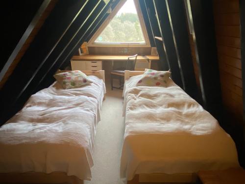 two beds in a room with a window at Ferienhaus im Feriendorf Freilingen (Eifel). in Freilingen