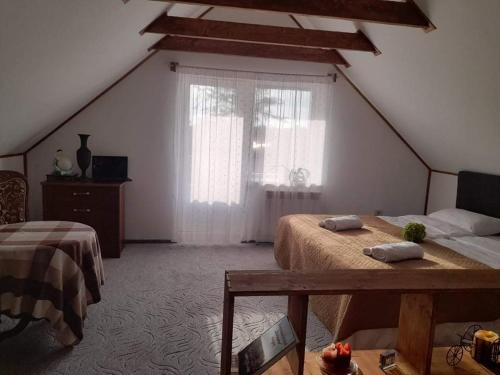 a attic bedroom with two beds and a window at Molynė in Kaulakiai