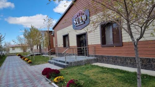 a building with a sign on the side of it at SULO Atyrau Hotel in Atyraū