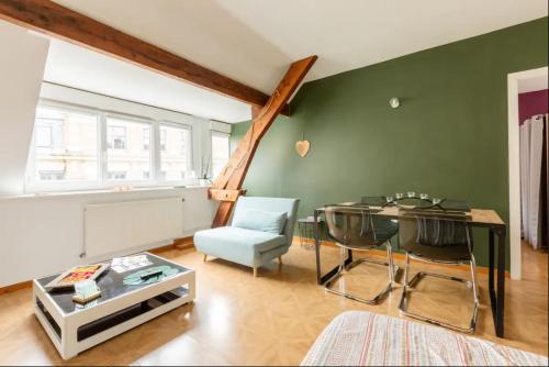 - un salon avec une table et un mur vert dans l'établissement 1 Apt 3 Cocooning, 54m2, Centre, à Valenciennes