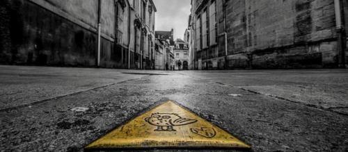 a yellow sign in the middle of an empty street at Maison Philippe Le Bon Hôtel, Restaurant & Bar le 19 in Dijon
