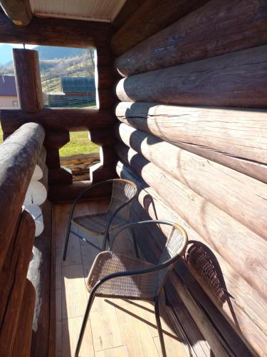 a chair on the porch of a log cabin at Маєток У ҐАЗДИ in Synevyrsʼka Polyana
