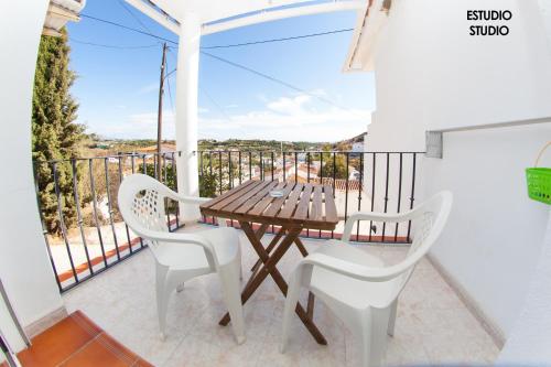 a wooden table and two chairs on a balcony at Apartamentos Rurales Santos in Benajarafe