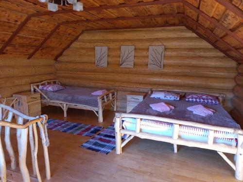 - une chambre dans une cabane en rondins avec un lit et un banc dans l'établissement Маєток У ҐАЗДИ, à Synevyrsʼka Polyana