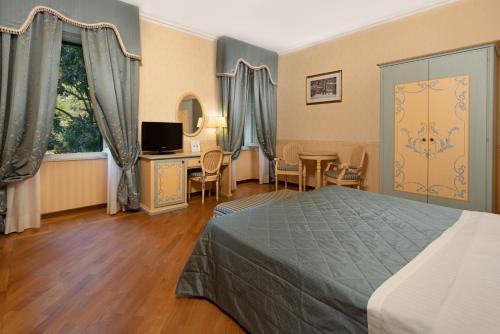 a hotel room with a bed and a table and chairs at Relais San Clemente in Perugia