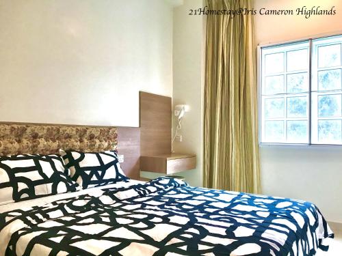 a bedroom with a black and white bed and a window at 21Homestay (3-Bedrooms) @ Iris Cameron Highlands in Cameron Highlands