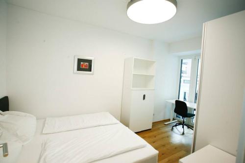 um quarto branco com uma cama e uma secretária em Top Central Apartment on Karlsplatz Vienna em Viena