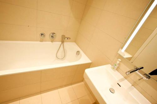 y baño con ducha, bañera y lavamanos. en Top Central Apartment on Karlsplatz Vienna, en Viena