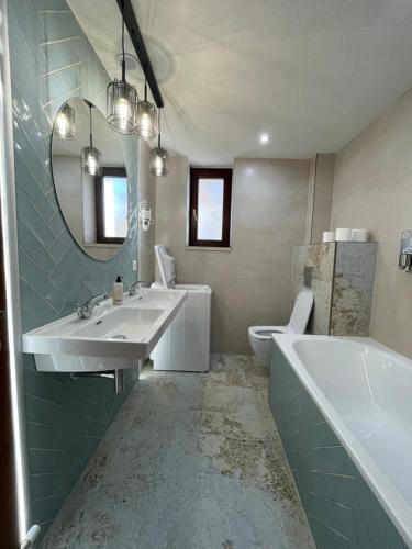 a bathroom with two sinks and a tub and a toilet at Wellness Villa Totina in Liptovský Mikuláš – Demänová