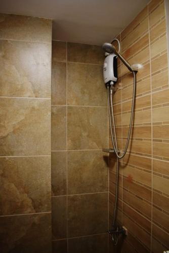 a bathroom with a shower with a blow dryer on the wall at Affordable Baguio Condo- Goshenland towers in Baguio